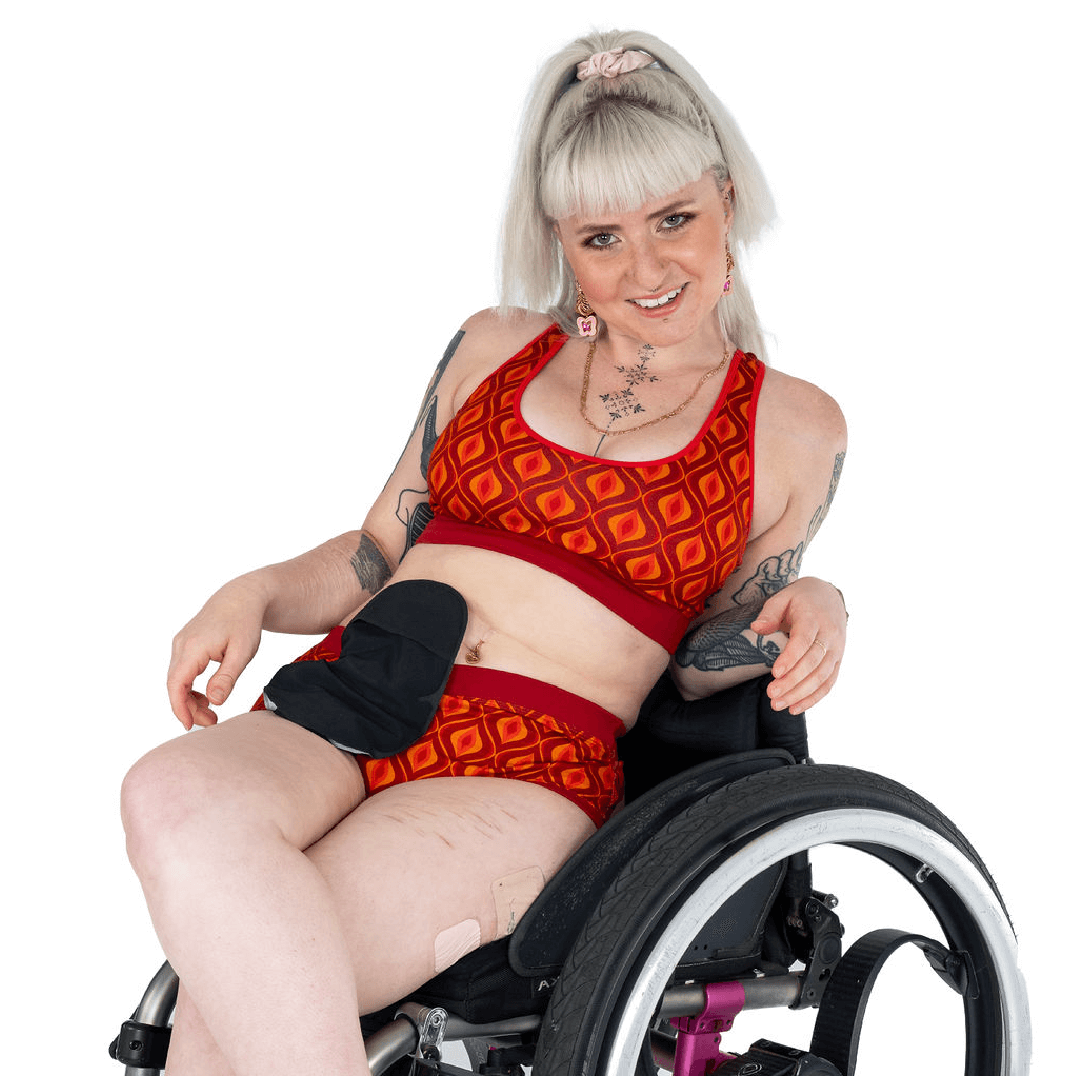 Jess is in her wheelchair wearing a Groovy bralette and briefs